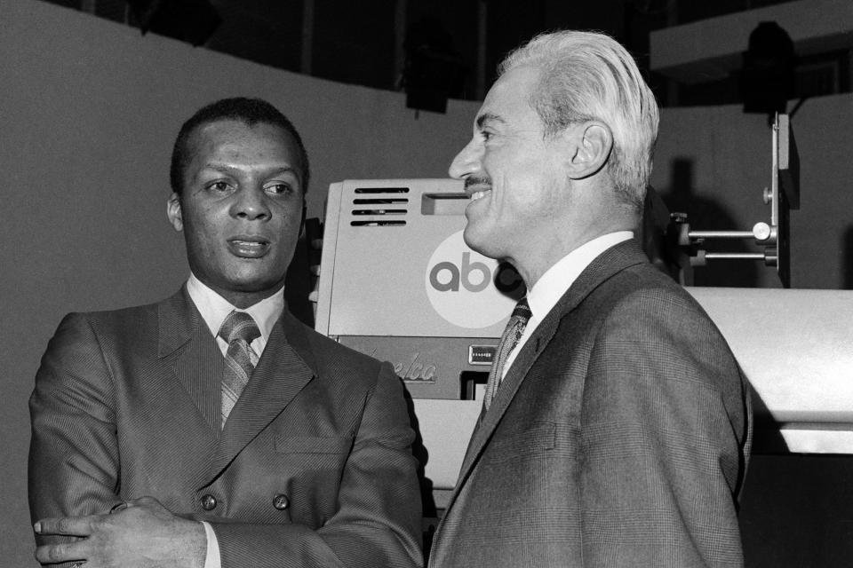 FILE - In this Jan. 3, 1970, file photo, baseball player Curt Flood, left, and Marvin Miller, Executive Director of the Baseball Players Association, wait inside ABC Television Studio before an appearance in New York. Flood set off the free-agent revolution 50 years ago Tuesday, Dec. 24, 2019, with a 128-word letter to baseball Commissioner Bowie Kuhn, two paragraphs that pretty much ended the career of a World Series champion regarded as among the sport's stars but united a union behind his cause. (AP Photo/File)