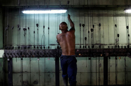 A miner holds a chain to get his clothes at the cloakroom inside the Wieczorek mine, in Nikiszowiec district in Katowice, Poland, November 26, 2018. REUTERS/Kacper Pempel