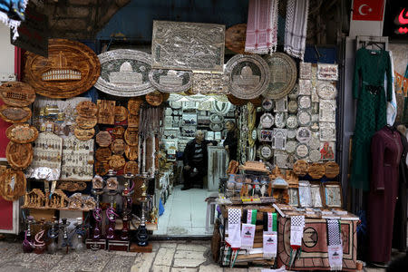 A man sits inside a shop in Jerusalem's Old City December 5, 2017 REUTERS/Ammar Awad