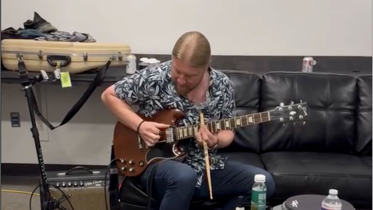  Derek Trucks plays slide on his Dickey Betts SG using a drumstick. 