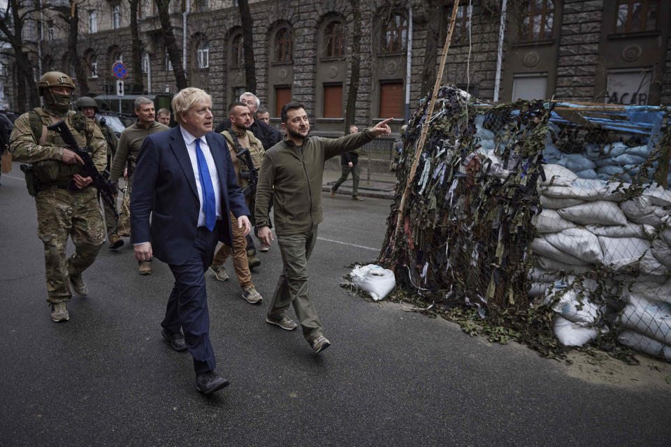 In this image provided by the Ukrainian Presidential Press Office, Ukrainian President Volodymyr Zelenskyy, center, and Britain's Prime Minister Boris Johnson, center left, walk in downtown Kyiv, Ukraine, Saturday, April 9, 2022. (Ukrainian Presidential Press Office via AP)