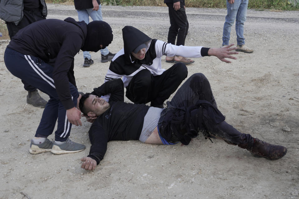 Palestinians help a wounded man during clashes with Israeli soldiers in the West Bank village of Silat al-Harithiya, near Jenin, Saturday, May 7, 2022, as Israeli forces demolished the home of Omar Jaradat was part of a group who shot and killed yeshiva student Yehuda Dimentman in the West Bank in Decemer 2021. (AP Photo/Majdi Mohammed)