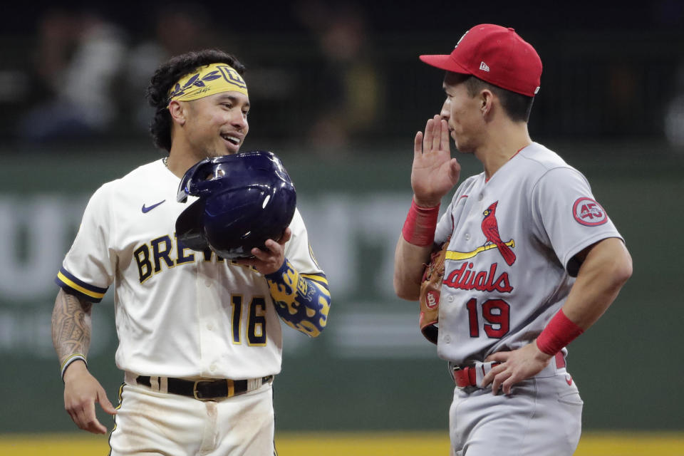 Milwaukee Brewers' Kolten Wong (16) laughs with St. Louis Cardinals' Tommy Edman (19) after hitting a double during the eighth inning of a baseball game Tuesday, Sept. 21, 2021, in Milwaukee. (AP Photo/Aaron Gash)