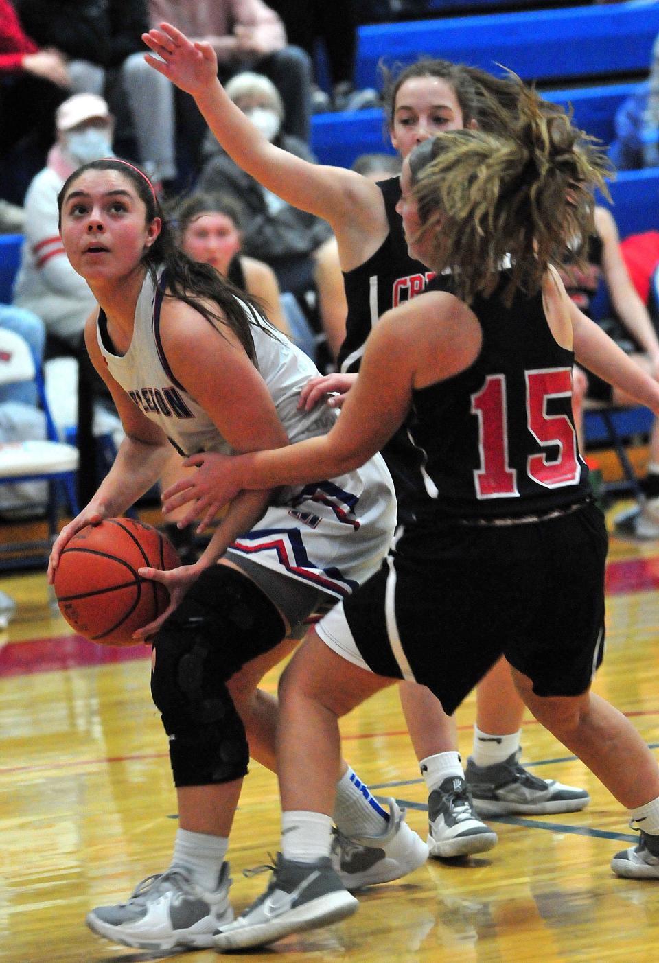 Mapleton High School’s Sara Hickey eyes the basket as Crestview High School’s Anna McFarland (15) and Georgia McFarland defend during basketball action at Mapleton High School Wednesday, Feb. 9, 2022. LIZ A. HOSFELD/FOR TIMES-GAZETTE.COM