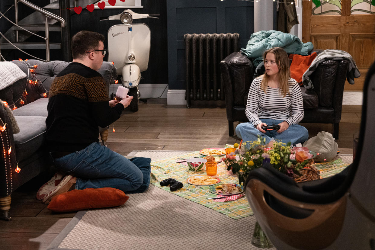 FROM ITV

STRICT EMBARGO
Print media - No Use Before Tuesday 8th February 2022
Online Media - No Use Before 0700hrs Tuesday 8th February 2022

Emmerdale - Ep 9287

Tuesday 15th February 2022

Vinny Dingle [BRADLEY JOHNSON] and Liv Flaherty [ISOBEL STEELE] happily play video games while she thanks him for taking her mind off of the teenagers recognising her in the Hide. When Vinny presents her with a jewellery box, Livâ€™s mortified when she misinterprets the romantic gift as a marriage proposal. 

Picture contact - David.crook@itv.com

Photographer - Mark Bruce

This photograph is (C) ITV Plc and can only be reproduced for editorial purposes directly in connection with the programme or event mentioned above, or ITV plc. Once made available by ITV plc Picture Desk, this photograph can be reproduced once only up until the transmission [TX] date and no reproduction fee will be charged. Any subsequent usage may incur a fee. This photograph must not be manipulated [excluding basic cropping] in a manner which alters the visual appearance of the person photographed deemed detrimental or inappropriate by ITV plc Picture Desk. This photograph must not be syndicated to any other company, publication or website, or permanently archived, without the express written permission of ITV Picture Desk. Full Terms and conditions are available on  www.itv.com/presscentre/itvpictures/terms
