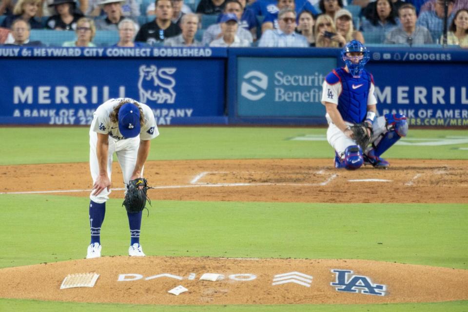 Dodgers pitcher Tyler Glasnow faces away from the catcher, rests his hands on his knees and looks down at the mound.