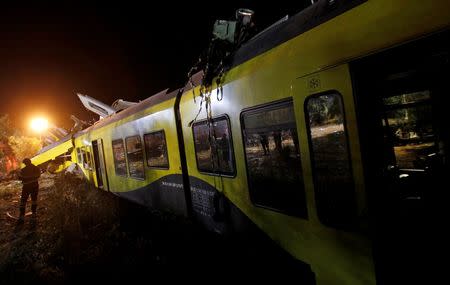 A rescuer works at the site where two passenger trains collided in the middle of an olive grove in the southern village of Corato, near Bari, Italy, July 12, 2016. REUTERS/Alessandro Garofalo