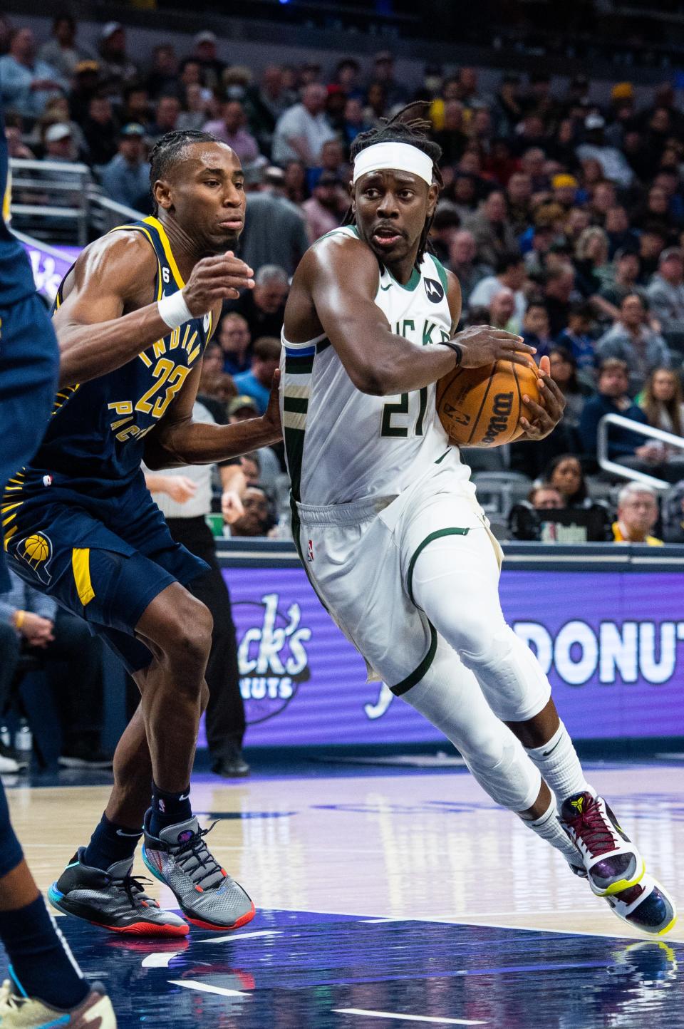 Mar 29, 2023; Indianapolis, Indiana, USA; Milwaukee Bucks guard Jrue Holiday (21) dribbles the ball while Indiana Pacers forward Aaron Nesmith (23) defends in the second quarter at Gainbridge Fieldhouse. Mandatory Credit: Trevor Ruszkowski-USA TODAY Sports