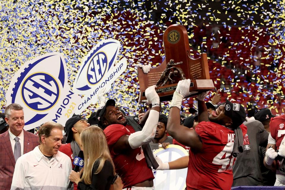 Crimson Tide inebacker Will Anderson Jr. (31), and defensive lineman Phidarian Mathis (48) lift the SEC championship trophy after their win against the Georgia Bulldogs at Mercedes-Benz Stadium.