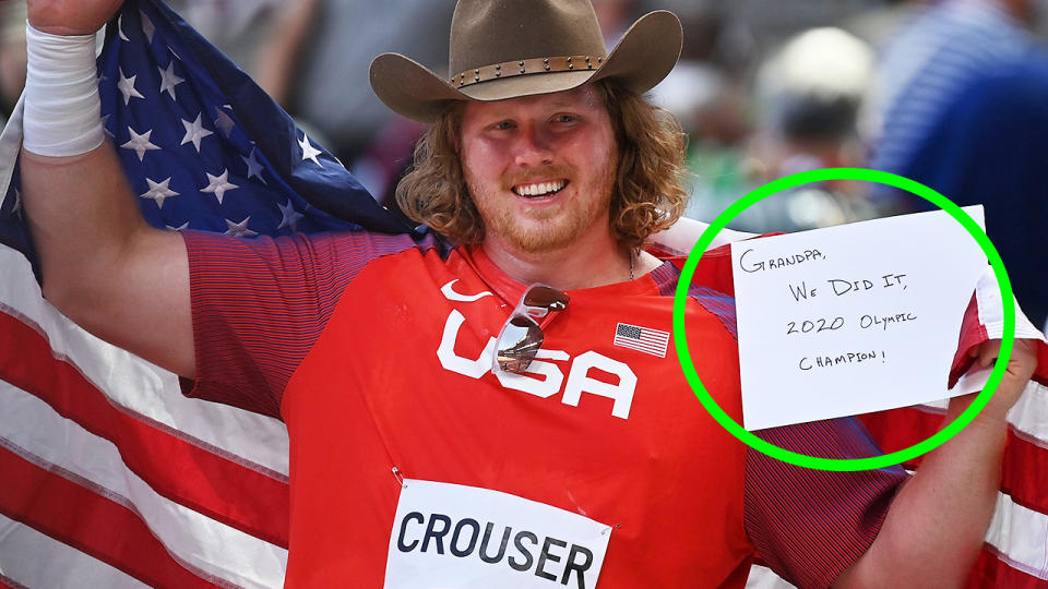 Ryan Crouser holds up a note written for his grandfather Larry after winning gold in the shot put at the Tokyo Olympics.