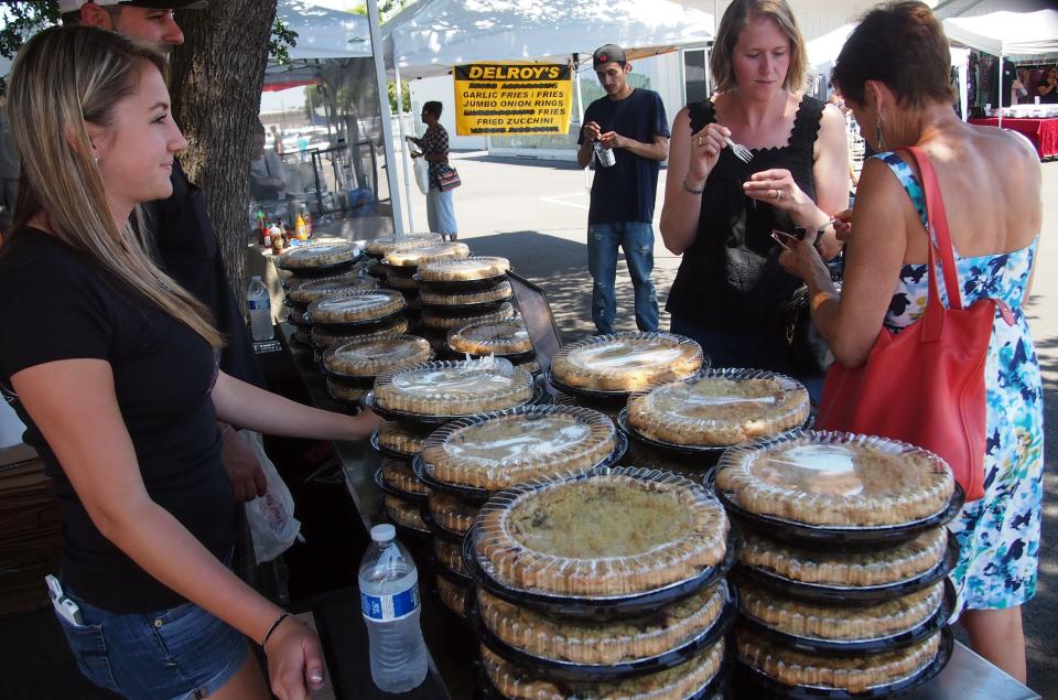 The Pie Company's Ashley Norwood, left, watches as Abby Pereira, center, and Judi Burkitt taste a sample of cherry pies on May 20, 2017, at the annual LInden Cherry Festival.