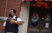 Police Commander Rahman Muhammad stands outside a funeral home where a shootout wounded 15, in the Auburn Gresham neighborhood in Chicago, Tuesday, Aug. 25, 2020. Muhammad says there's been a big shift since he began work in the 6th district 25 years ago when gun violence revolved around narcotics or some other criminal enterprise. Now, he says, social media is often the driving force behind the shootings. Disputes often start out online as gang members who've grown up together are now rivals taunting each other over petty matters that escalate into tragedy. (AP Photo/David Goldman)