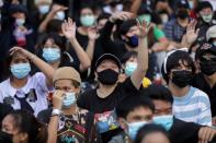 Pro-democracy protesters use hand signals during an anti-government protest in Bangkok