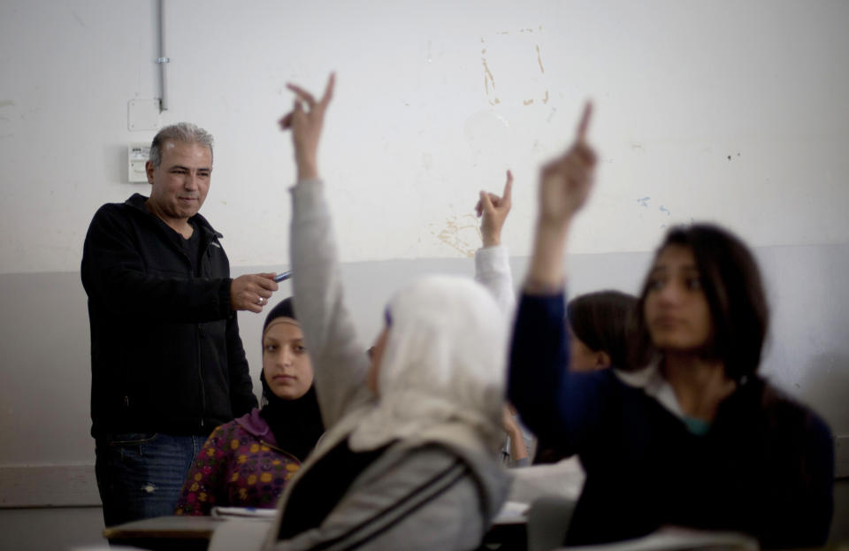 In this Thursday, April 3, 2014 photo, Palestinian Esmat Mansour, a former prisoner who was released after 20 years in Israeli jail, teaches Hebrew to students at a school in the village of Taybeh, near the West Bank city of Ramallah. Mansour was 16 when, in October 1993, he helped three older teens stab to death an Israeli man. Mansour said the time in Israeli prison changed him. (AP Photo/Majdi Mohammed)