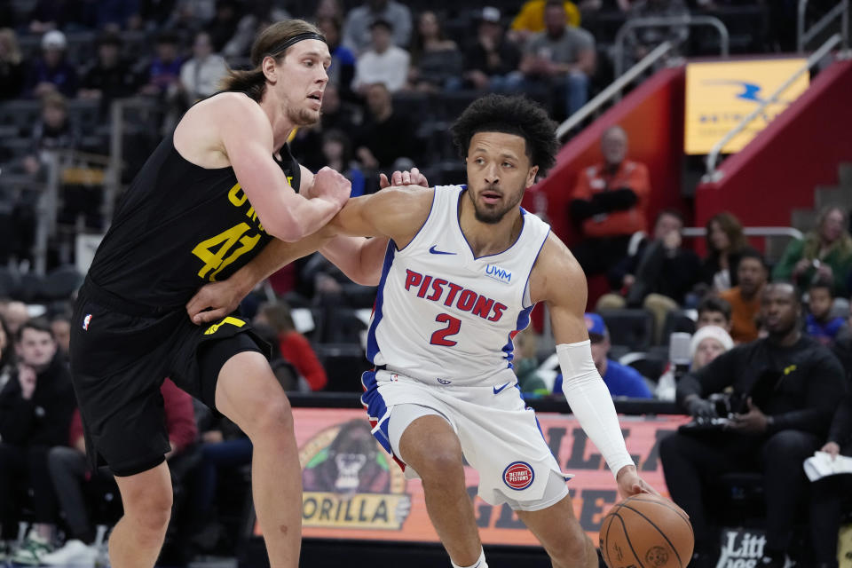 Detroit Pistons guard Cade Cunningham (2) drives as Utah Jazz forward Kelly Olynyk (41) defends during the first half of an NBA basketball game, Thursday, Dec. 21, 2023, in Detroit. (AP Photo/Carlos Osorio)