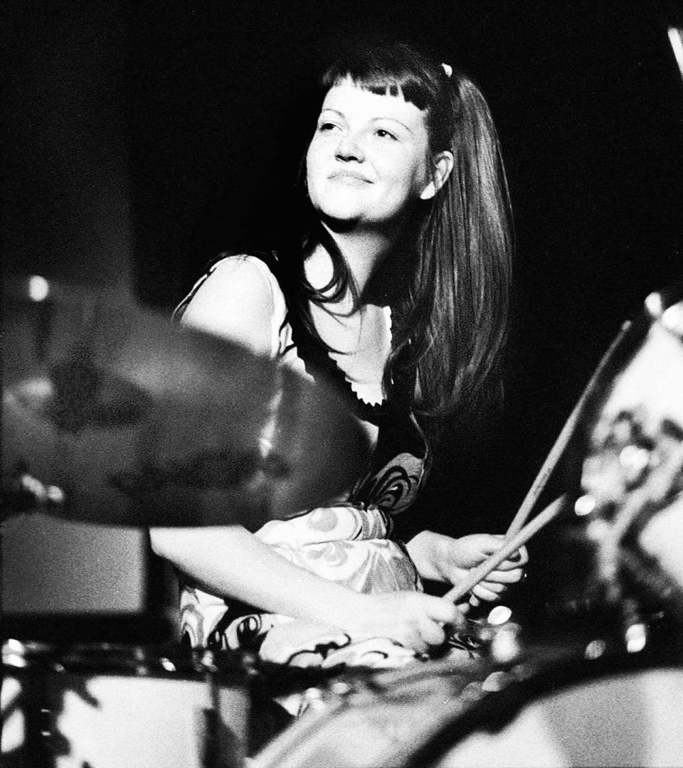 meg white smiles behind a drumset