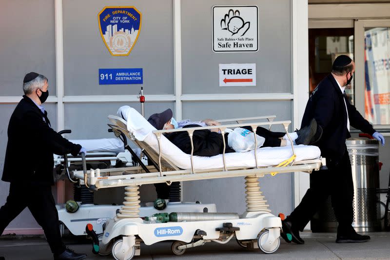 Paramedics wheel a patient from triage area outside Maimonides Medical Center in Brooklyn