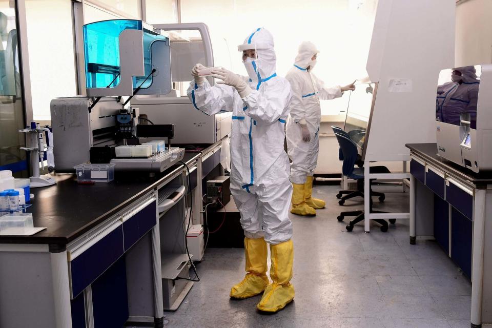 Laboratory technicians work on testing samples from people to be tested for the Covid-19 (AFP via Getty Images)