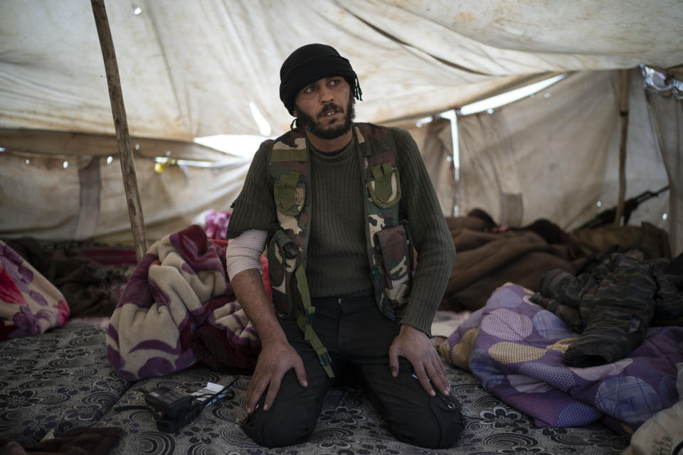 Un combatiente de las Fuerzas Democráticas Sirias respaldadas por Estados Unidos está sentado al interior de una carpa sobre una colina en el desierto afuera de la aldea de Baghouz, Siria, el jueves 14 de febrero de 2019. (AP Foto/Felipe Dana)