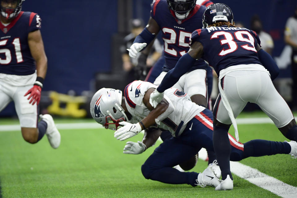 New England Patriots running back Damien Harris, bottom, fumbles the ball at the goal line as he is hit by Houston Texans cornerback Terrance Mitchell (39) during the first half of an NFL football game Sunday, Oct. 10, 2021, in Houston. Houston recovered the fumble. (AP Photo/Justin Rex)