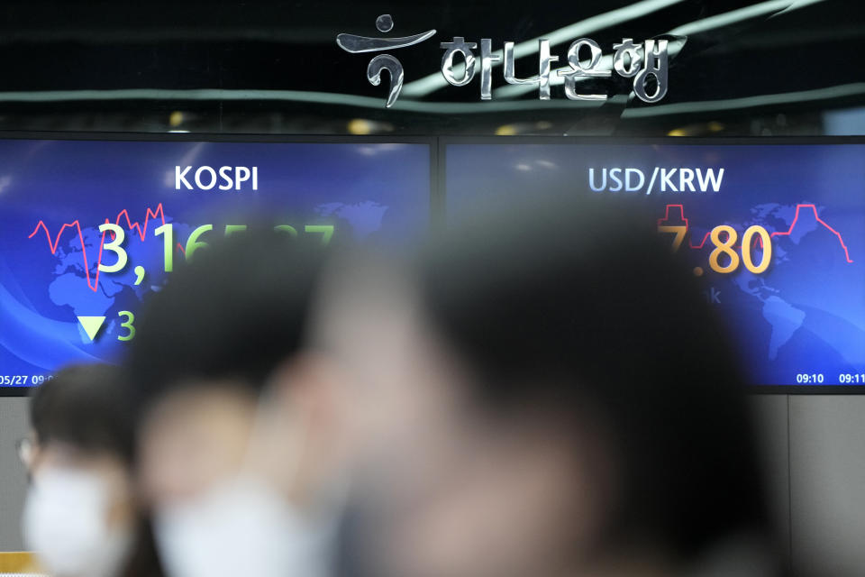 Currency traders watch computer monitors near the screens showing the Korea Composite Stock Price Index (KOSPI), left, and the foreign exchange rate between U.S. dollar and South Korean won at the foreign exchange dealing room in Seoul, South Korea, Thursday, May 27, 2021. Asian shares fell Thursday, as investors watched for signs of inflation and awaited U.S. economic data expected later in the day. (AP Photo/Lee Jin-man)