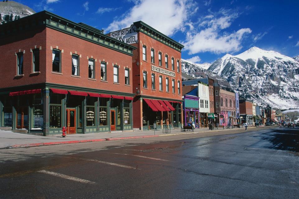 Main street in Telluride, Colorado with storefronts and a mountain in the distance