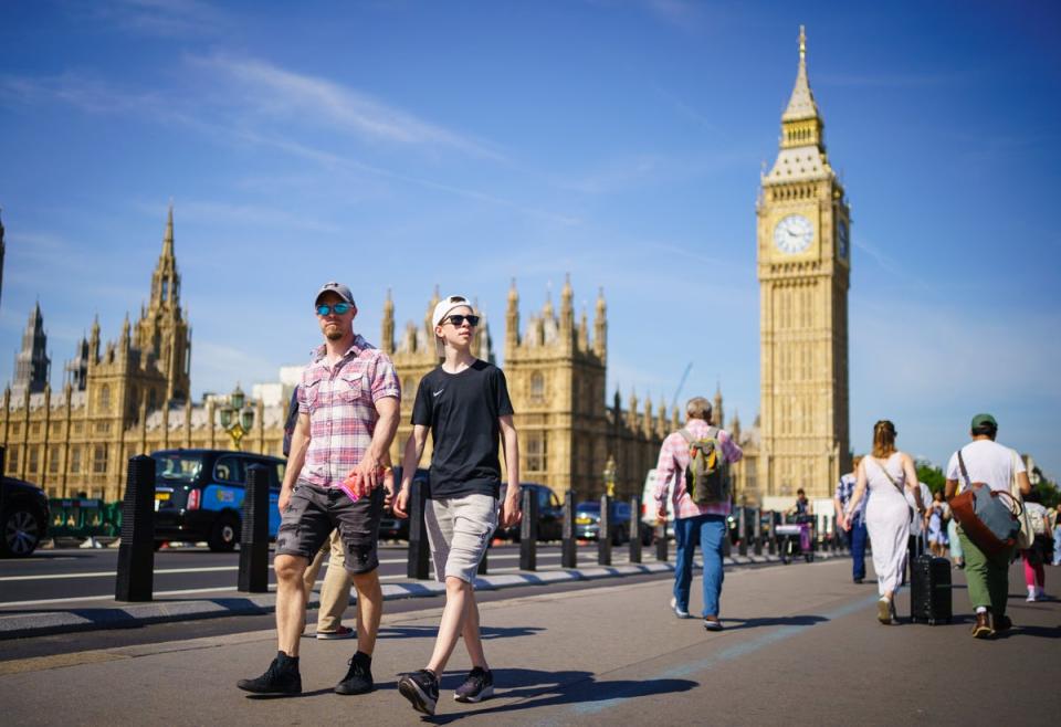 People enjoy the sunny weather on Westminster Bridge, by the Houses of Parliament, London (Dominic Lipinski/PA) (PA Wire)