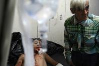 A badly injured Syrian lies on a hospital bed in the Idlib provinve town of Zardana following deadly air strikes on June 7, 2018, blamed on government ally Russia