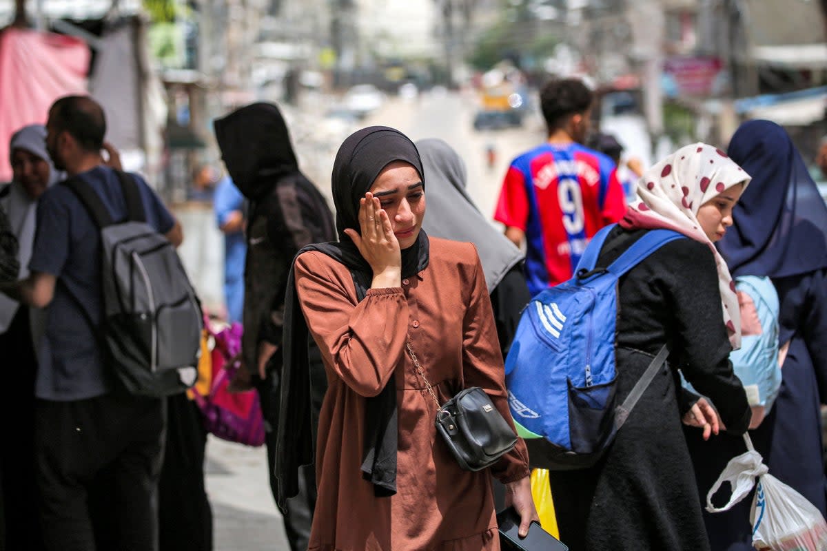 A woman wipes away tears before evacuating from Rafah in the southern Gaza Strip (AFP via Getty Images)