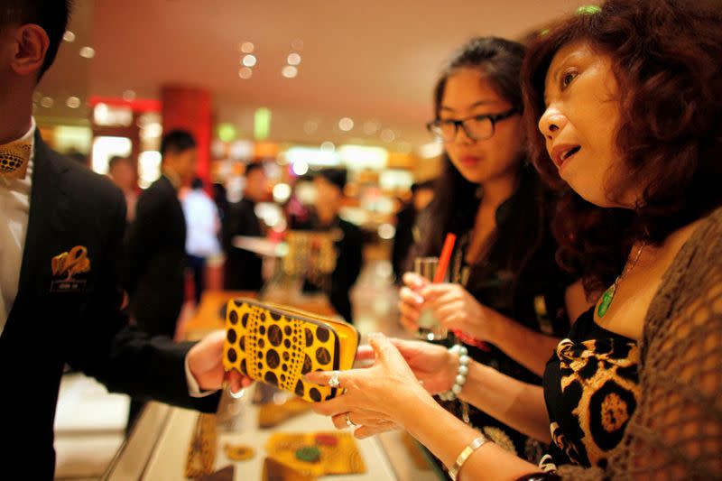 FOTO DE ARCHIVO. Una mujer compra en una tienda Louis Vuitton durante la cuarta edición de Vogue Fashion's Night Out en el centro de Shanghái