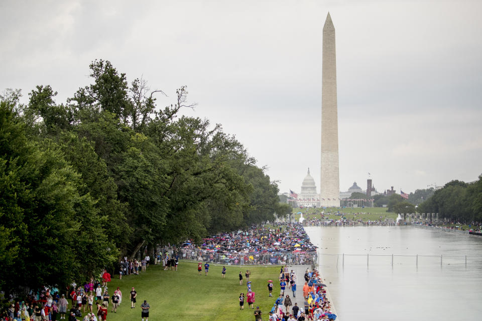 Crowds gather in the rain along the Reflecting Pool before President Donald Trump's 'Salute to America' event honoring service branches on Independence Day, Thursday, July 4, 2019, in Washington. President Donald Trump is promising military tanks along with "Incredible Flyovers & biggest ever Fireworks!" for the Fourth of July. (AP Photo/Andrew Harnik)