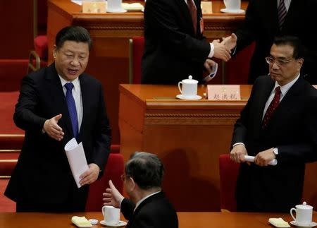 China's President Xi Jinping shakes hands with Chairman of the National Committee of Chinese People's Political Consultative Conference (CPPCC) Yu Zhengsheng as China's Premier Li Keqiang looks on, during the closing session of the CPPCC at the Great Hall of the People in Beijing, China, March 13, 2017. REUTERS/Jason Lee