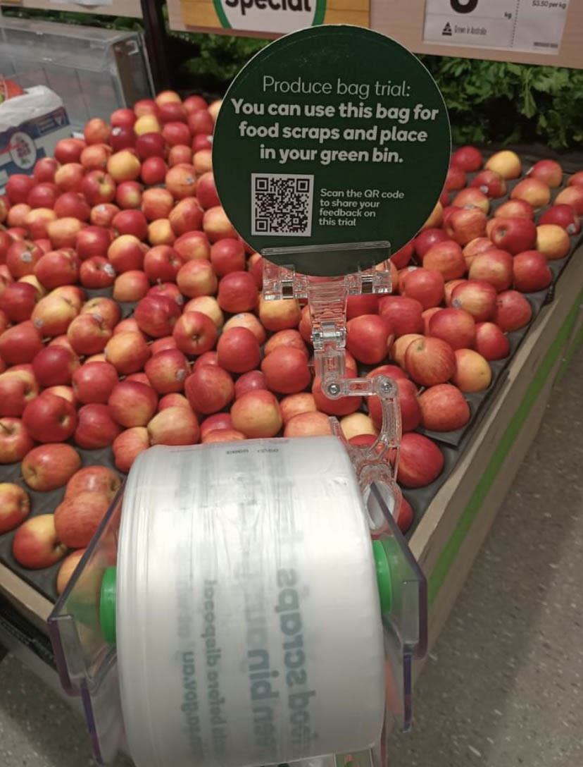 Woolworths produce bags in front of an apple display. Source: Facebook