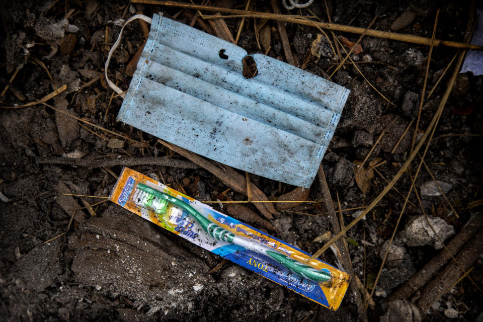 A face mask and an unused toothbrush of a deceased COVID-19 victim lie in a cremation ground in Gauhati, India, Friday, July 2, 2021. The personal belongings of cremated COVID-19 victims lie strewn around the grounds of the Ulubari cremation ground in Gauhati, the biggest city in India’s remote northeast. It's a fundamental change from the rites and traditions that surround death in the Hindu religion. And, perhaps, also reflects the grim fears grieving people shaken by the deaths of their loved ones — have of the virus in India, where more than 405,000 people have died. (AP Photo/Anupam Nath)