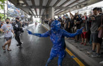 A pro-democracy protester covered in blue paint gestures on a road during a protest in Udom Suk, suburbs of Bangkok, Thailand, Saturday, Oct. 17, 2020. The authorities in Bangkok shut down mass transit systems and set up roadblocks Saturday as Thailand’s capital faced a fourth straight day of determined anti-government protests. (AP Photo/Gemunu Amarasinghe)