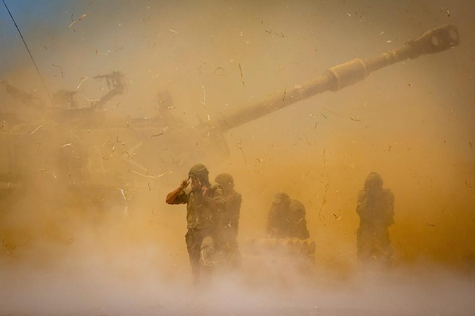 An Israeli artillery unit fires toward targets in Gaza Strip, at the Israeli Gaza border, Wednesday, May 12, 2021.