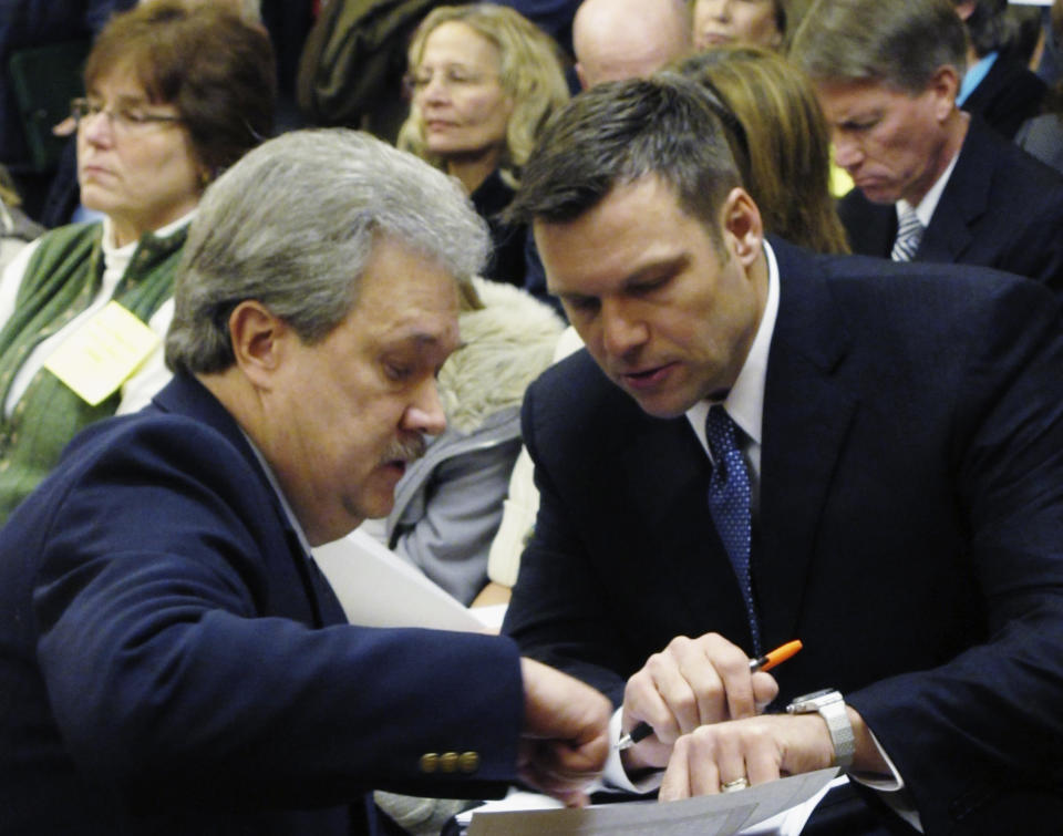 FILE - In this Jan. 31, 2011, file photo, Kansas Secretary of State Kris Kobach, right, confers with Assistant Secretary of State Eric Rucker during a Kansas House Elections Committee hearing on Kobach's bill for cracking down on election fraud at the Statehouse in Topeka, Kan. Kobach says he's stepping aside from his duties as the state's top elections official while his hotly contested Republican primary race with Gov. Jeff Colyer remains unresolved. Kobach announced his decision Friday, Aug. 10, 2018, in a letter to Colyer. Kobach said he is handing his election duties over to Rucker. (AP Photo/John Hanna, File)