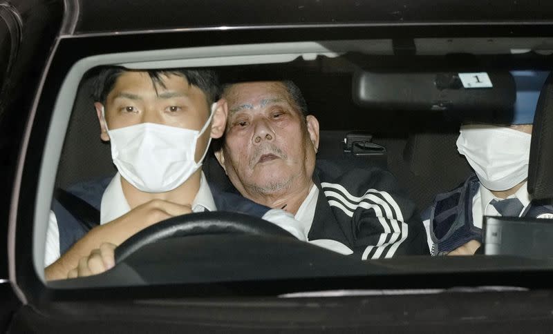 Tsuneo Suzuki, a suspected gunman who took hostages in a post office is taken to a police station in Warabi