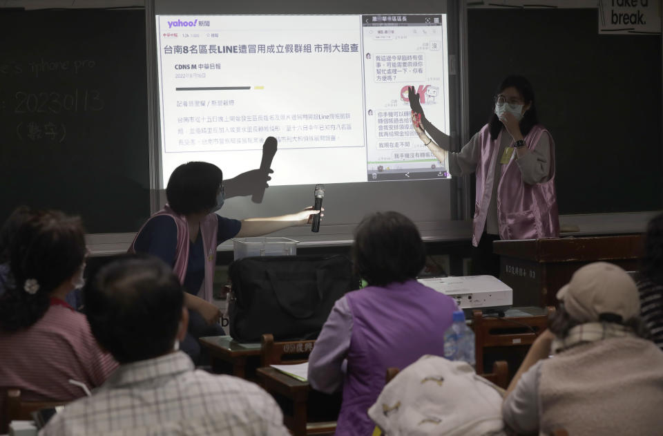 Volunteers of Fake News Cleaner guide students through the LINE app to identify fake news during a class in Kaohsiung City, southern Taiwan, Thursday, March 16, 2023. An anti-misinformation group in Taiwan called Fake News Cleaner has hosted more than 500 events, connecting with college students, elementary-school children — and the seniors that, some say, are the most vulnerable to such efforts. (AP Photo/Chiang Ying-ying)