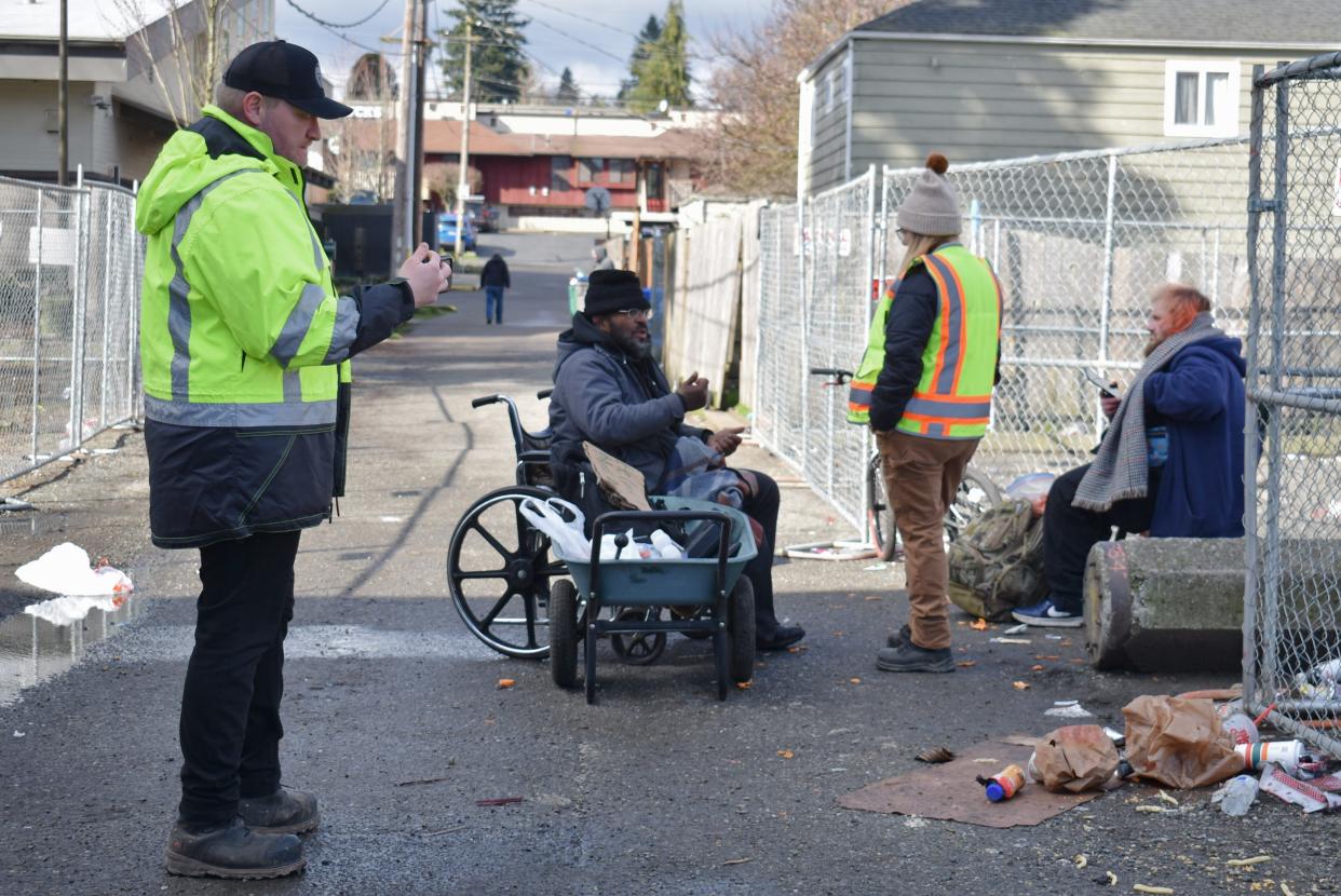 Brendan Perko, at left, and Trisha Munson, right, walk between Salvation Army and Martin Luther King Jr. Street doing outreach on behalf of Commonstreet Consulting. The two are meeting with Jeremy White Eagle, who they are helping to apply to the Benedict House shelter in Bremerton.