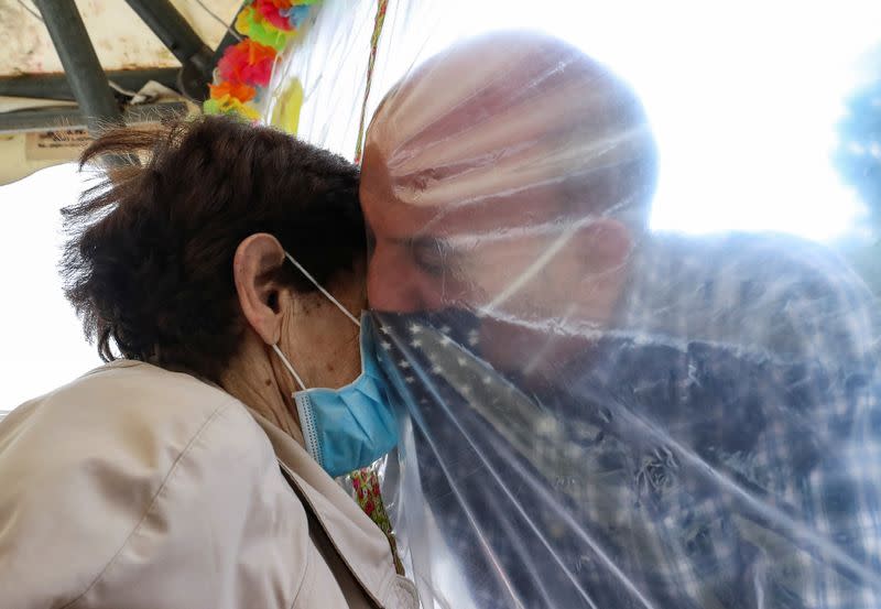 Residents at Belgian nursing home "Le Jardin de Picardie" enjoy hugs and cuddle through a wall made with plastic sheets to protect against potential coronavirus disease (COVID19) in Peruwelz