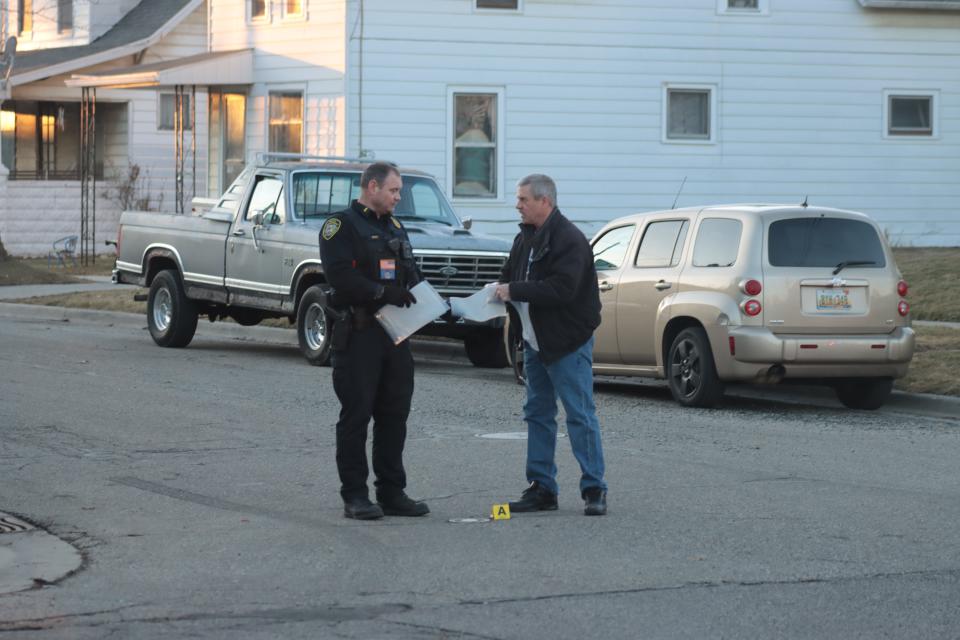 Lt. Randy Spence, left, and Detective Greg Lanford of the Adrian Police Department collect evidence Feb. 13 at the intersection of Frank and Tecumseh streets where a shooting occurred between the occupants of two vehicles. Stories about crime and other police matters were among the most read in 2023.