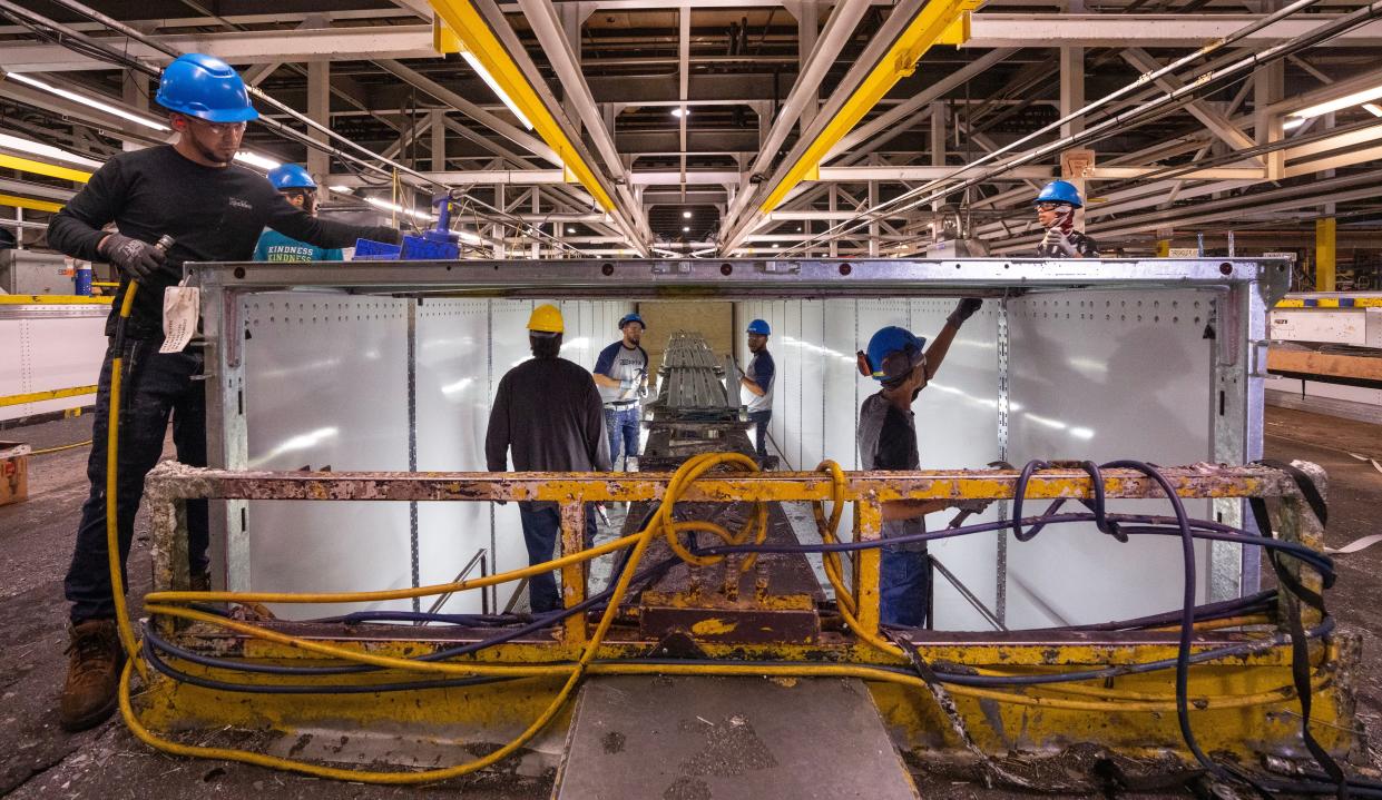 Workers install the roof on a 53-foot dry van trailer at Stoughton Trailers in Stoughton.