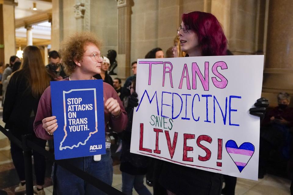 FILE - Protesters stand outside of the Senate chamber at the Indiana Statehouse, Wednesday, Feb. 22, 2023, in Indianapolis. Indiana Republican state Senators voted Tuesday, Feb. 28, to advance a ban on all gender-affirming care for those under 18, the latest in this year's conservative movement by states aiming to limit the rights of transgender youth. (AP Photo/Darron Cummings, File)