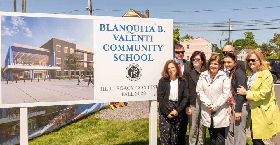 The family of Blanquita Valenti stands to the right of the newly unveiled plaque for the Blanquita B. Valenti Community School at the project's groundbreaking in 2021.