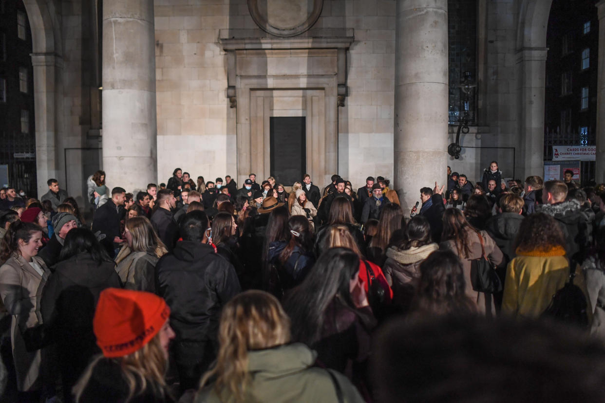 LONDON, ENGLAND  - DECEMBER 05:  Crowds of people listen to a busker in Covent Garden on December 5, 2020 in London, England. On Tuesday night, Dec 1, MPs voted in favour of government proposals to enter England into a tiered system of lockdown beginning at midnight. Residents of Tier Two - High Alert can socialise with anyone they live with or who is in their support bubble in any indoor setting, whether at home or in a public place. Outdoors they must observe the rule of six. Pubs and bars must close, unless operating as restaurants. Hospitality venues can only serve alcohol with substantial meals and must close between 11pm and 5am with last orders called at 10pm. Organised indoor sport, physical activity and exercise classes will be permitted if it is possible for people to avoid mixing with people they do not live with. Schools remain open. (Photo by Peter Summers/Getty Images)