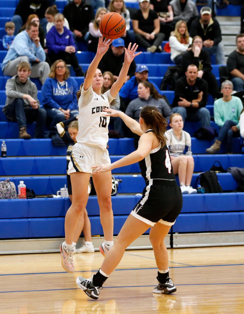 New Prairie senior Jolie Jonhs (10) shoots a '3' over John Glenn senior Sophia Romer during the bi-county girls basketball tournament championship game Saturday, Jan. 20, 2024, at LaVille High School in Lakeville.