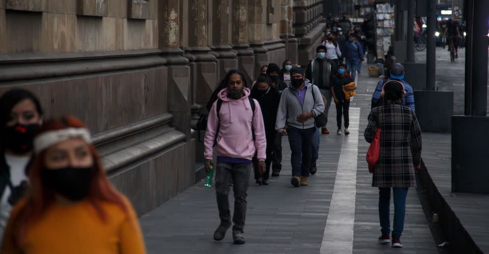 Ciudadanos caminan en calles de CDMX en semáforo rojo