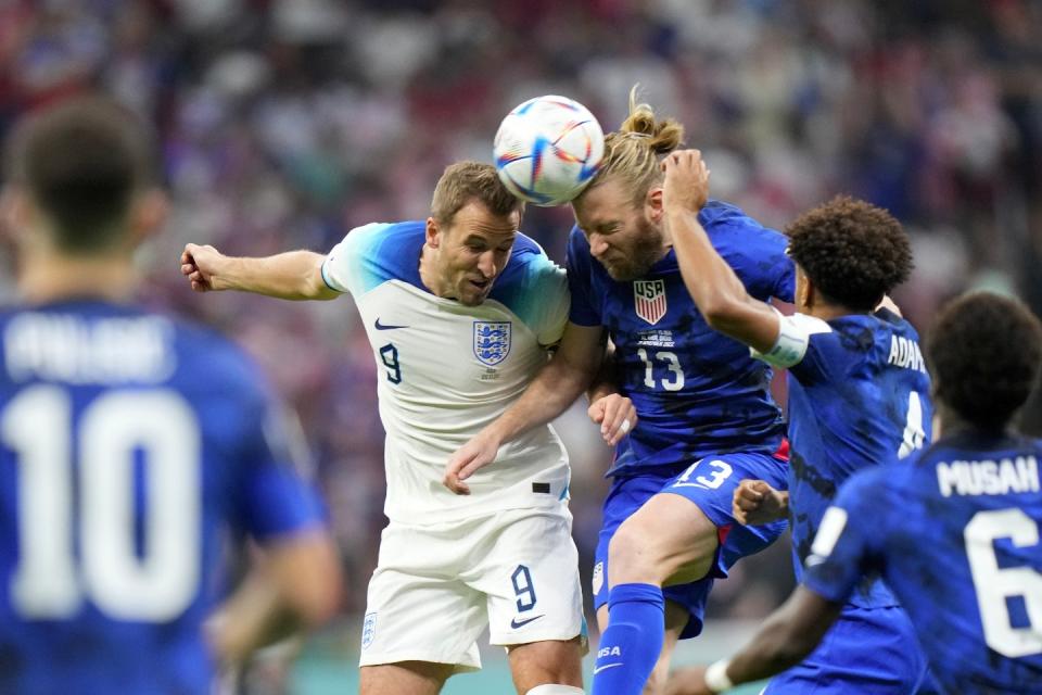 England's Harry Kane, center left, jumps for the ball with Tim Ream of the United States during the World Cup group B football match between England and The United States, at the Al Bayt Stadium in Al Khor , Qatar, Friday, Nov. 25, 2022. (AP Photo/Luca Bruno)