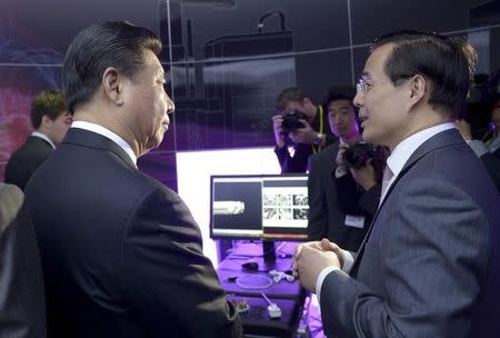 Professor Guang-Zhong Yang speaks with China's President Xi Jinping (L) during a visit to the Hamlyn Centre for Medical Robotics at Imperial College in London, Britain October 21, 2015. REUTERS/Anthony Devlin/pool